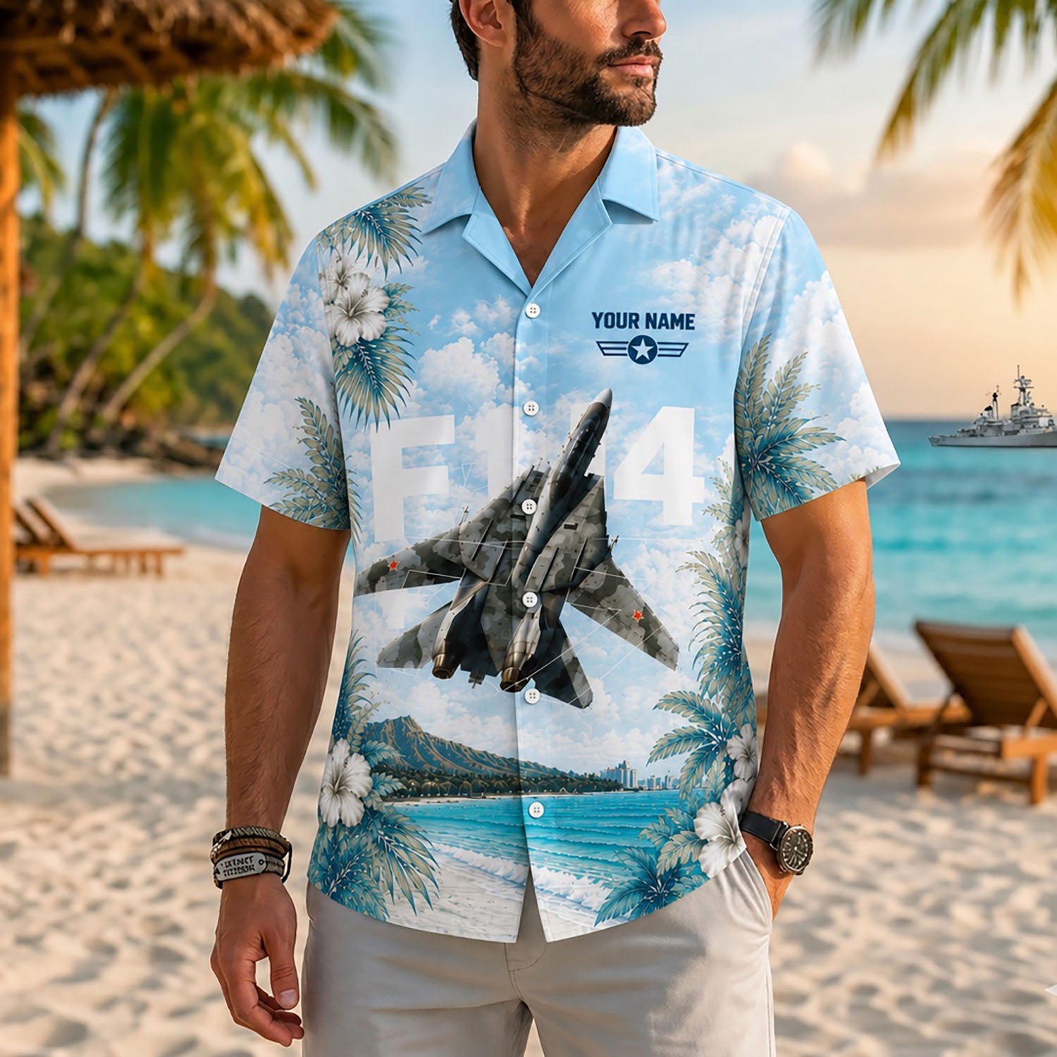 Close-up front view of a male model on a tropical resort beach wearing the custom F14 fighter jet sky blue shirt