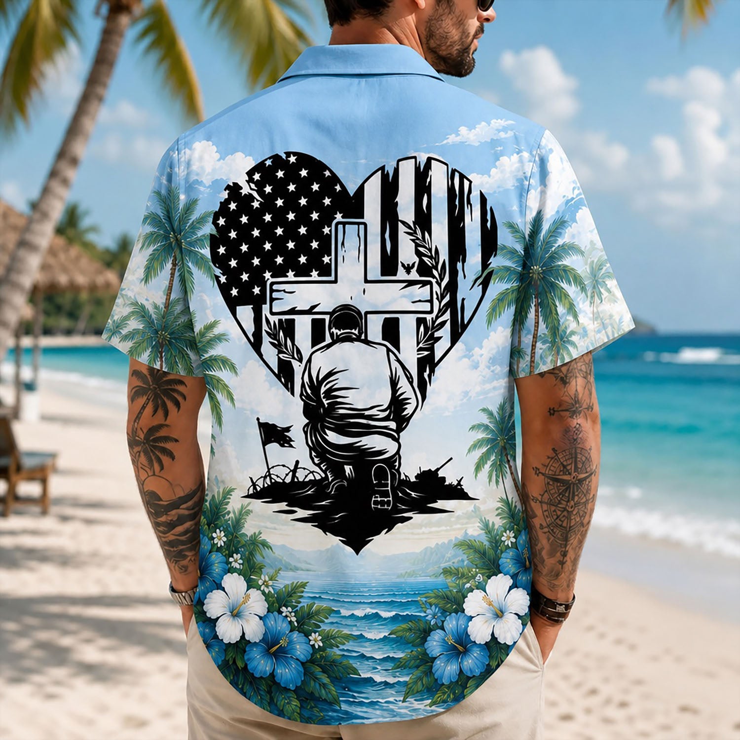 Back view lifestyle of a man showing the striking American flag heart and kneeling warrior graphics by the tropical seashore