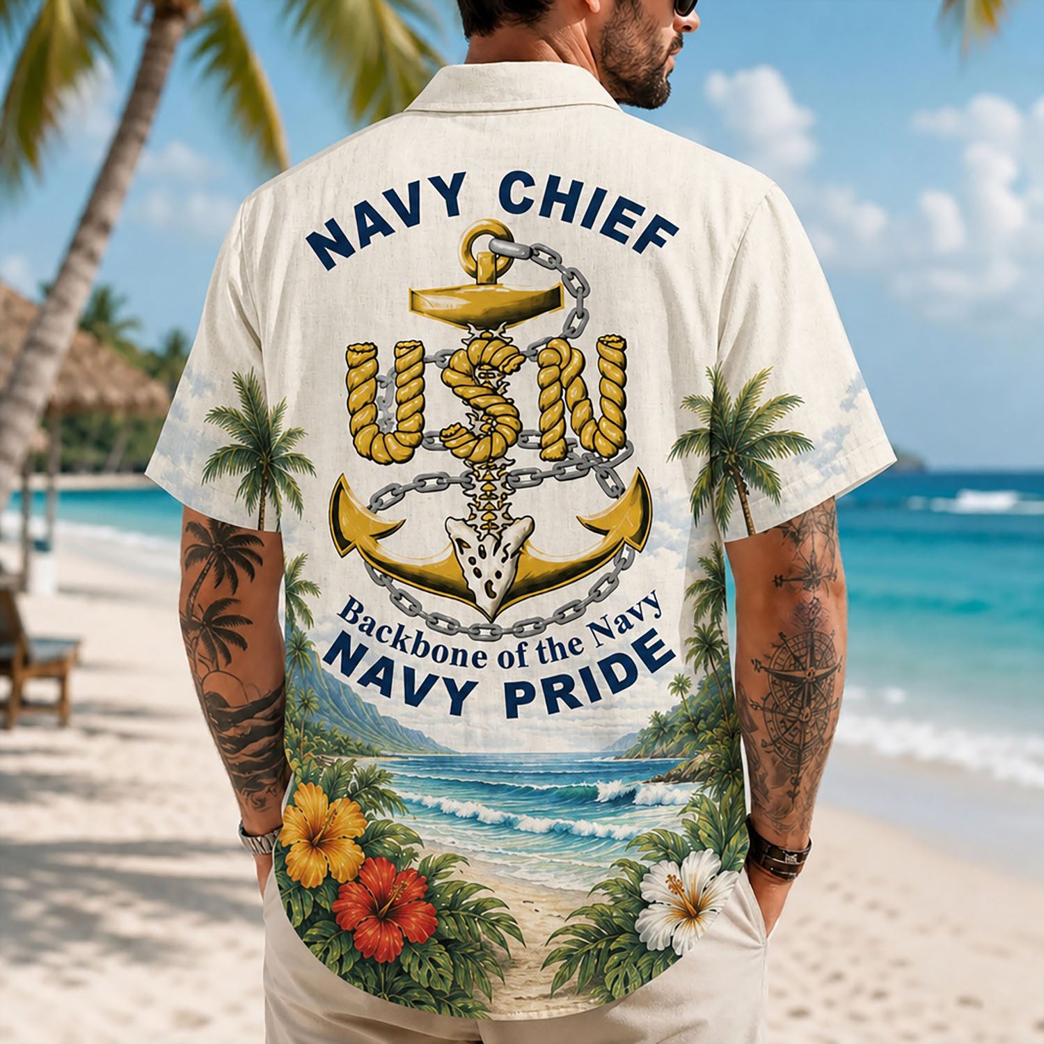 Back view lifestyle of a man showing the detailed rope-textured USN anchor graphic and patriotic naval phrases by the sea