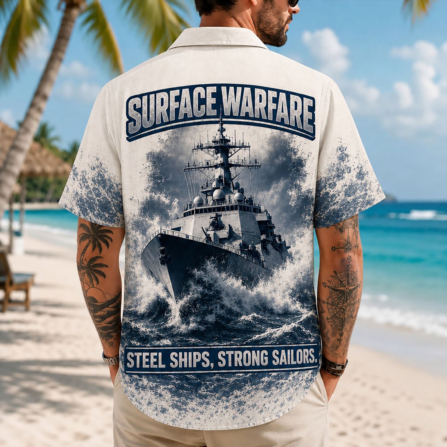 Back view lifestyle of a man showing the large-scale battleship graphic print and patriotic US Navy sailor quotes on the beach