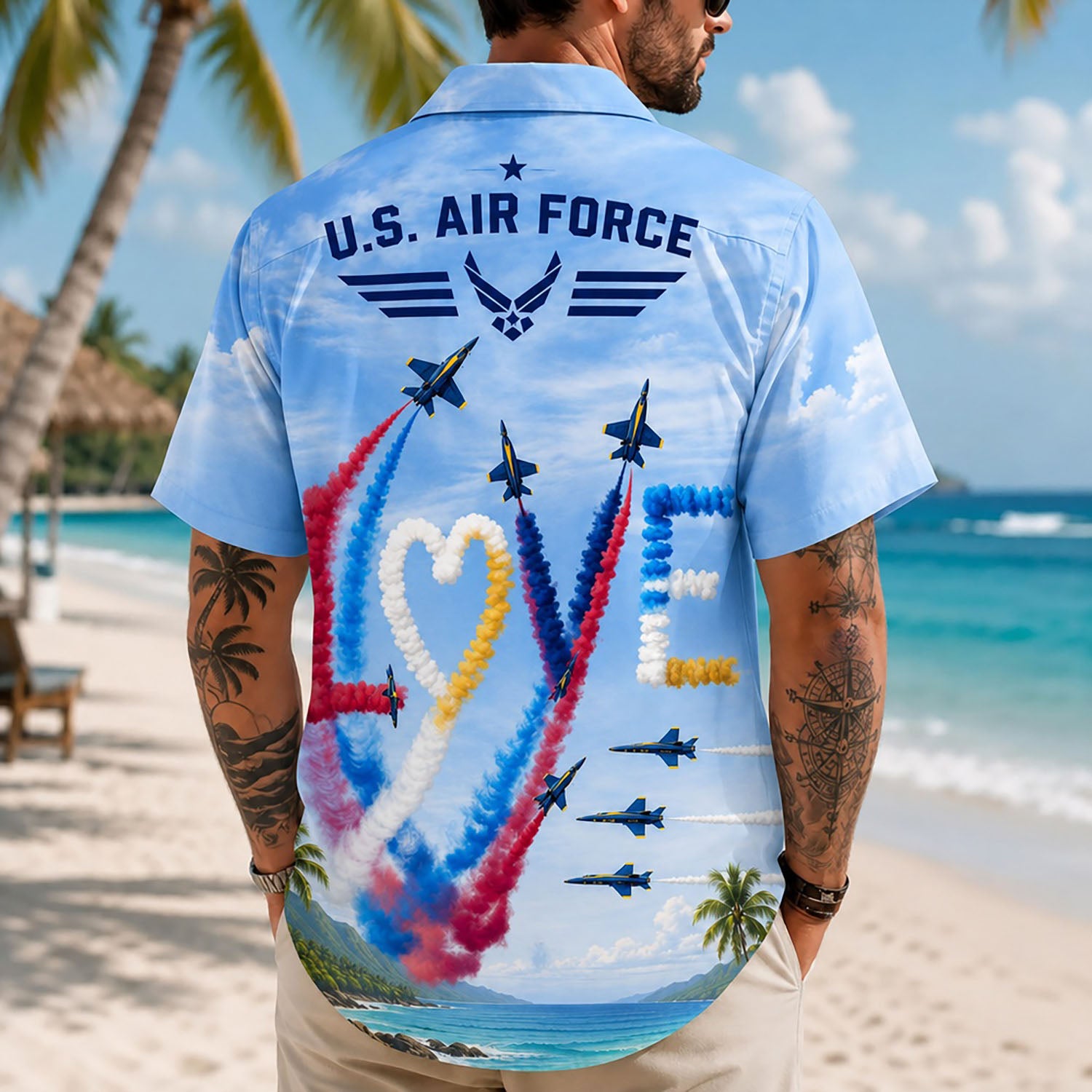 Back view lifestyle of a man modeling the shirt with the artistic "LOVE" smoke trail design and tropical beach background