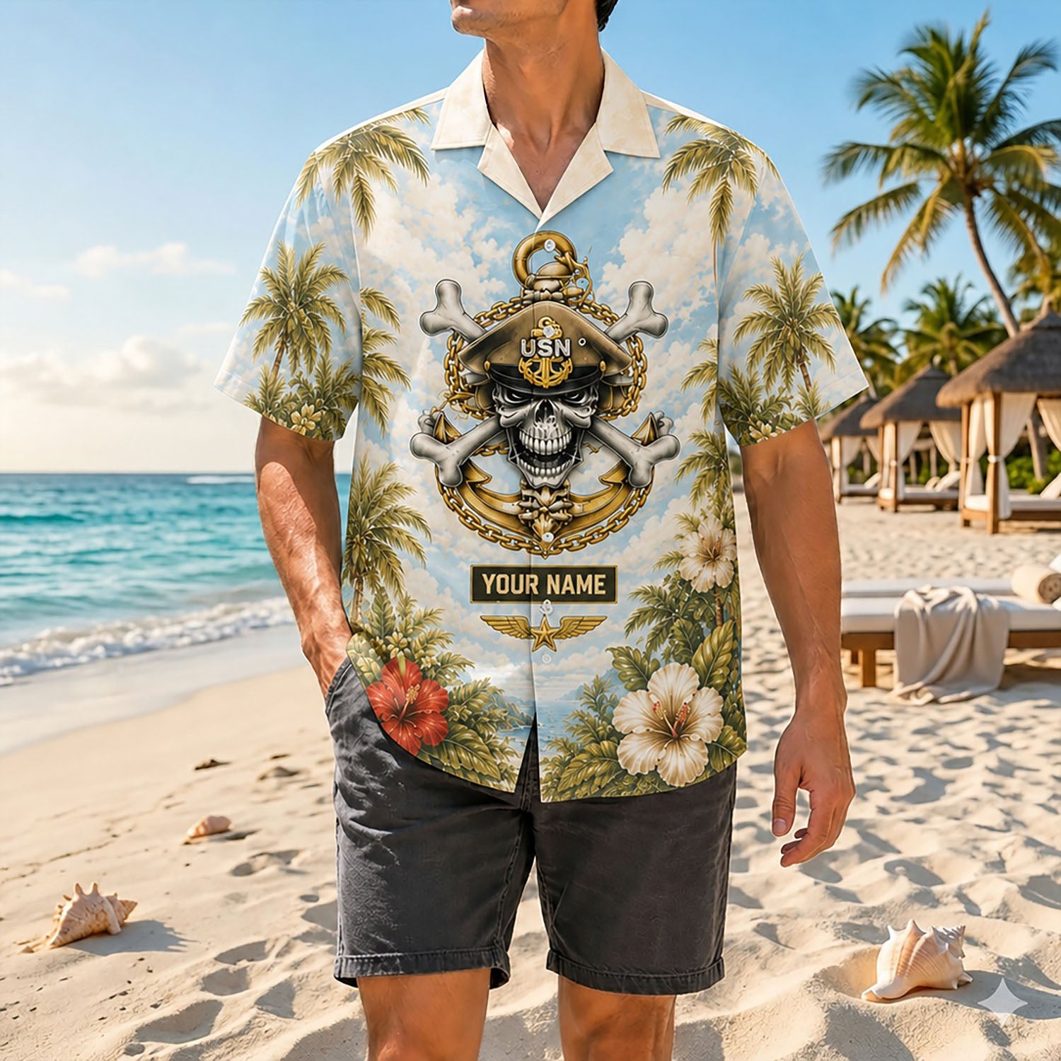 Full shot of a male model posing by the ocean waves wearing the custom name USN skull shirt paired with dark grey casual shorts