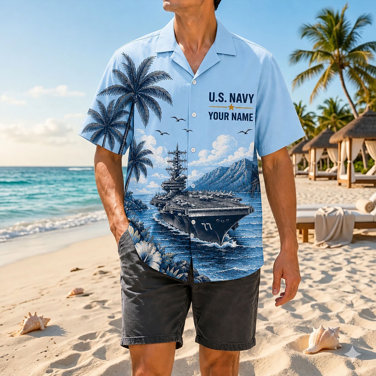 Full shot of a male model posing on a sunny shore wearing the personalized US Navy CVN-77 aircraft carrier tropical shirt paired with dark gray shorts