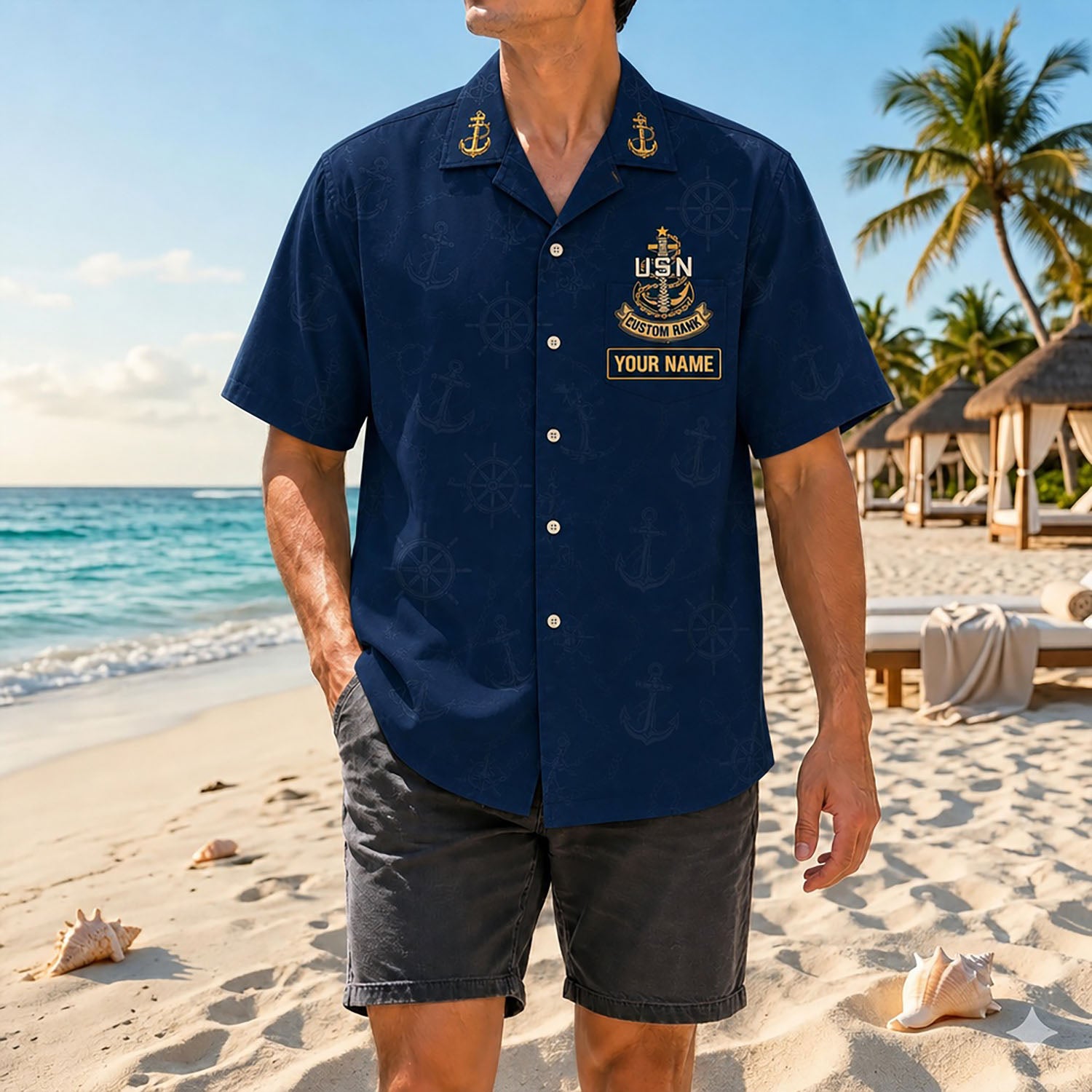 Full shot of a male model posing on a sunny shore wearing the custom US Navy Chiefs Backbone Hawaiian shirt with gray shorts