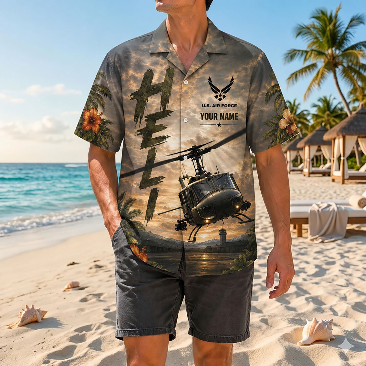 Full shot of a male model standing on sand wearing the custom name Huey chopper aviation shirt paired with dark casual shorts