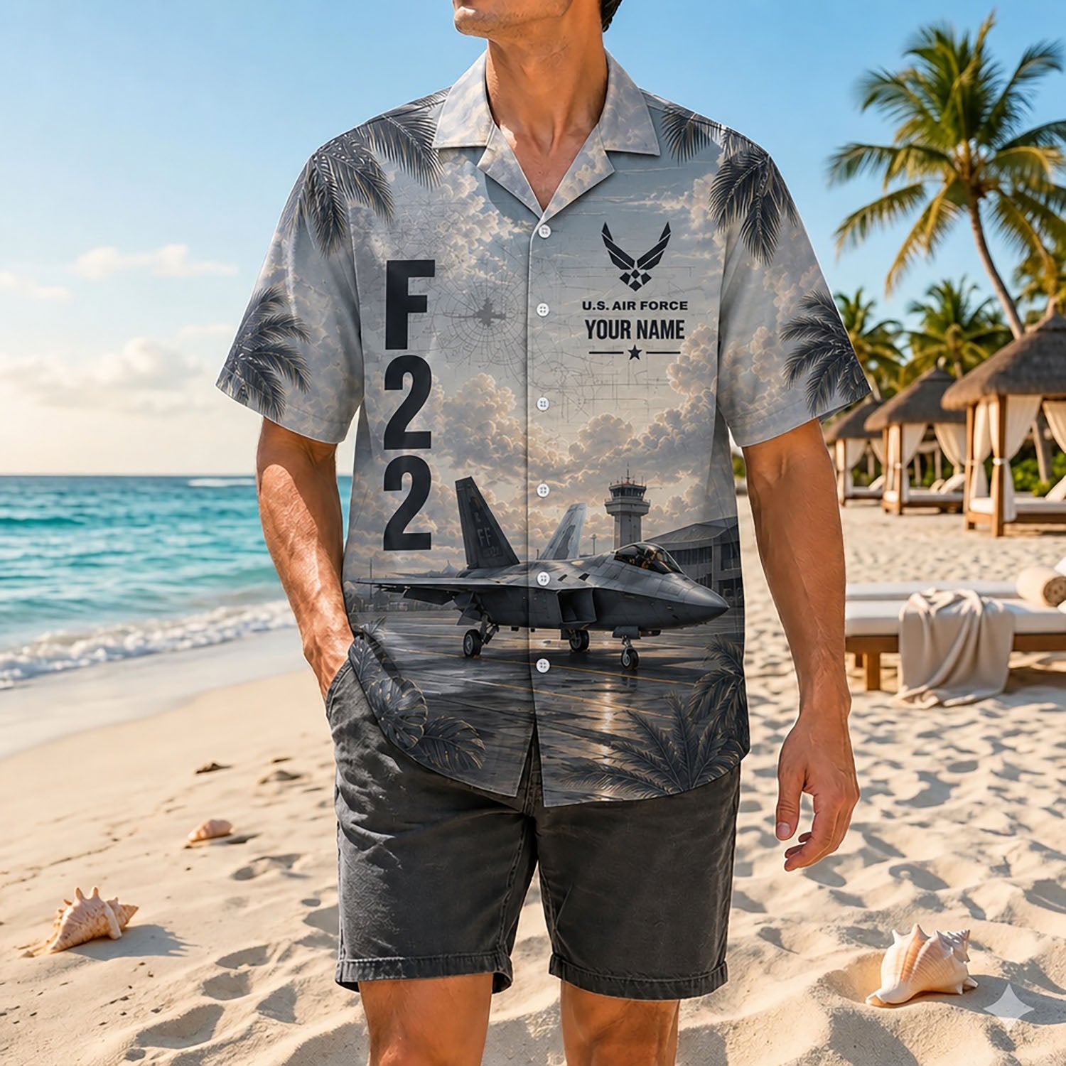 Full-body shot of a man modeling the custom F-22 stealth jet airpower shirt on a sandy shore paired with dark grey casual shorts