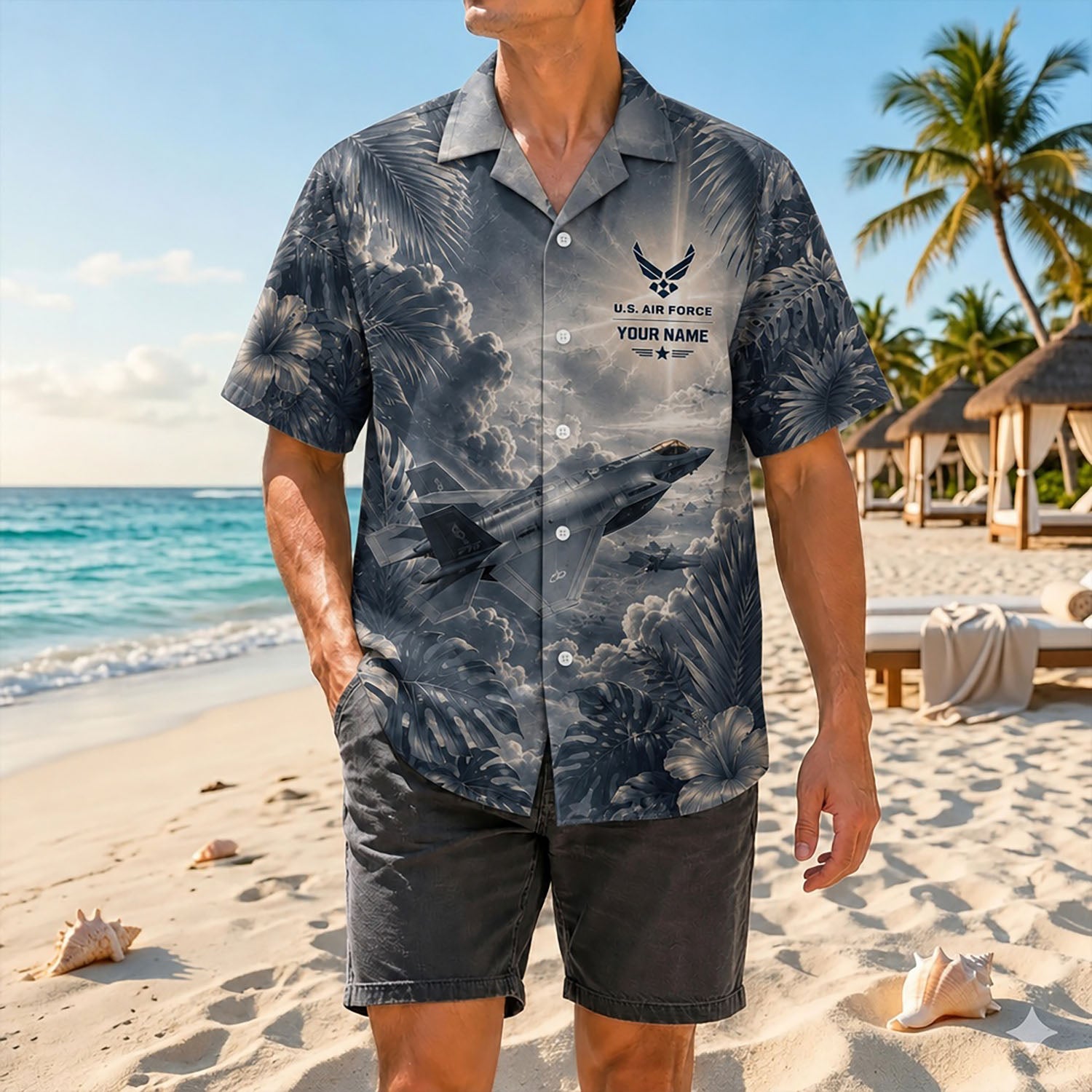 Full-body shot of a man modeling the dark military aviation F-35 shirt on a sandy shore paired with charcoal grey casual shorts