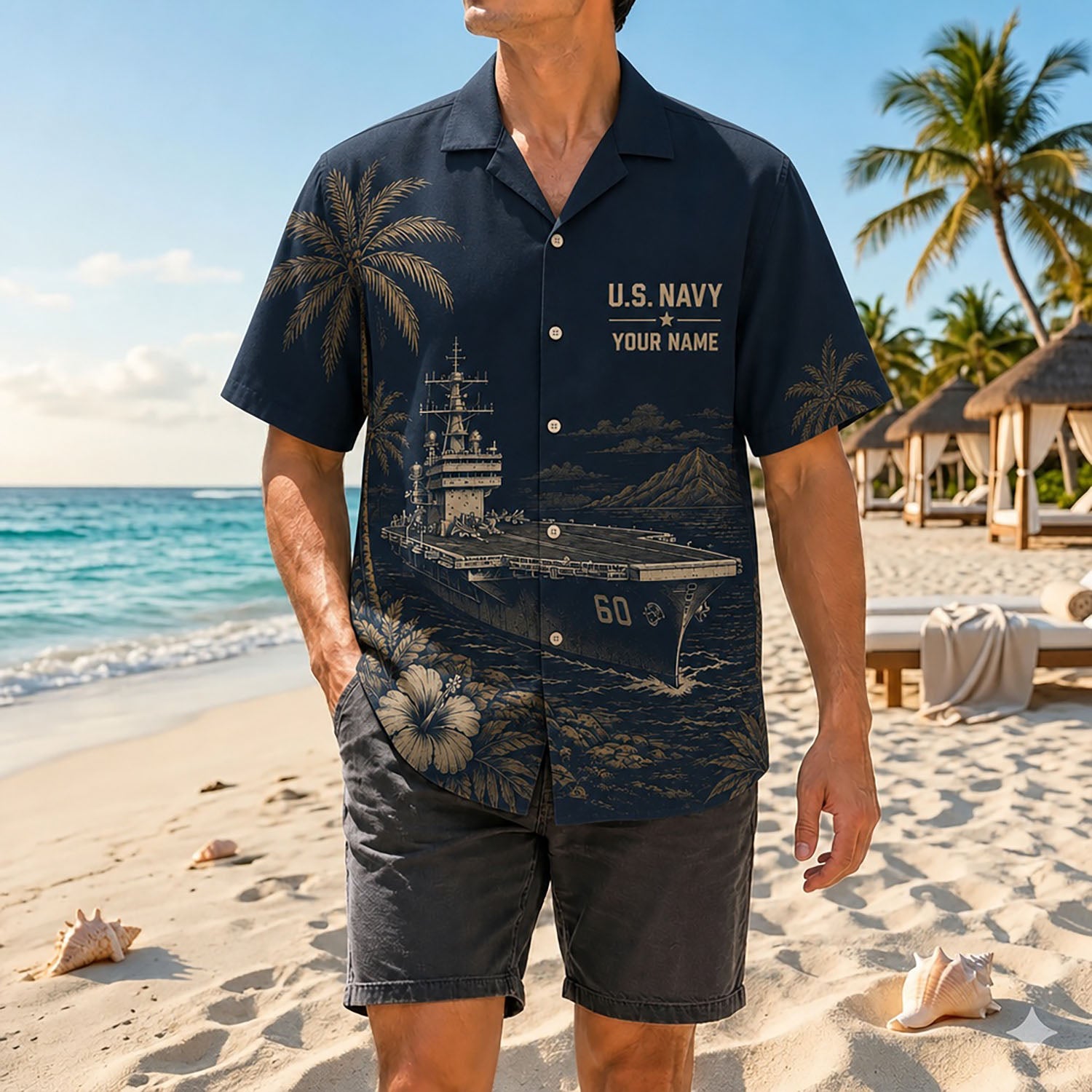 Full shot of a male model standing on sand wearing the custom name USS Saratoga CV-60 shirt paired with dark grey casual shorts