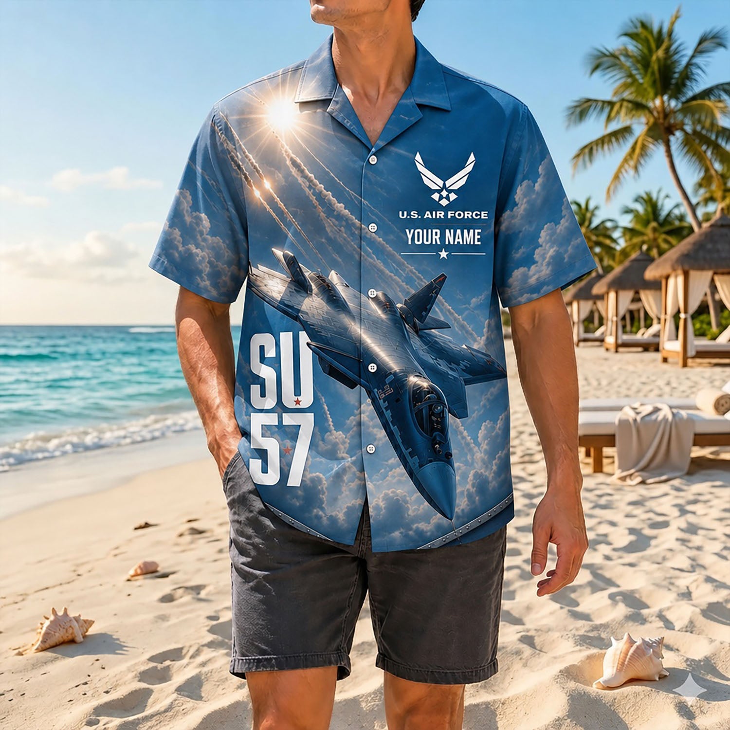 Full-body shot of a model wearing the dynamic sky blue Su-57 jet engine trail shirt on a sandy coast paired with dark casual shorts