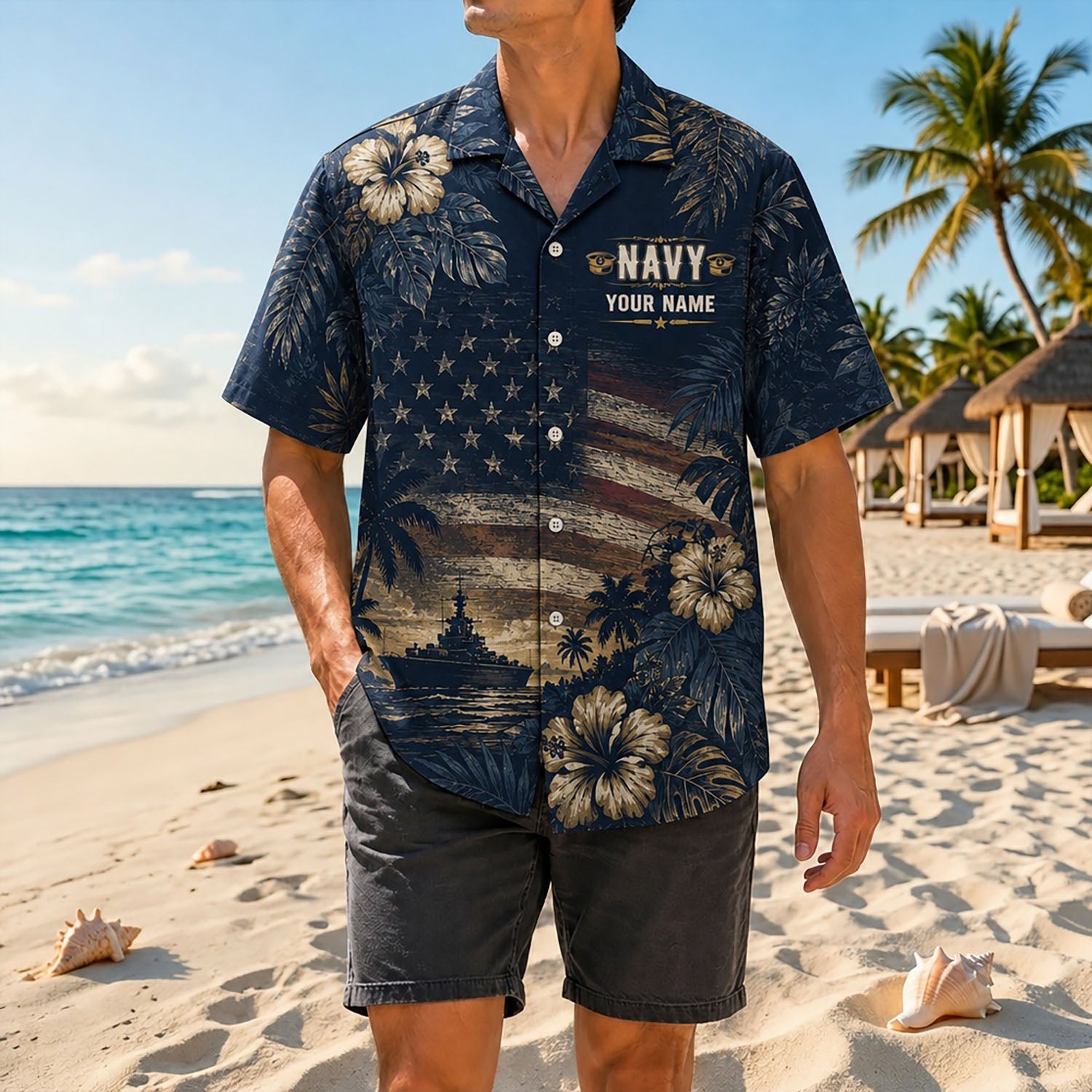 Full shot of a male model on the tropical sand wearing the custom name US Navy flag shirt paired with casual dark grey shorts