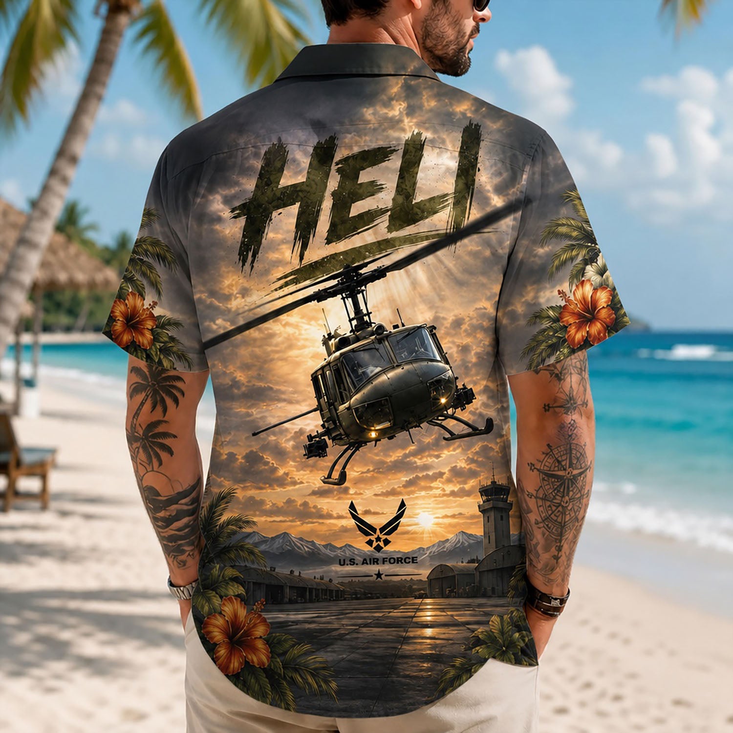 Back view lifestyle of a man showcasing the large iconic Huey helicopter print and U.S. Air Force insignia on a beach