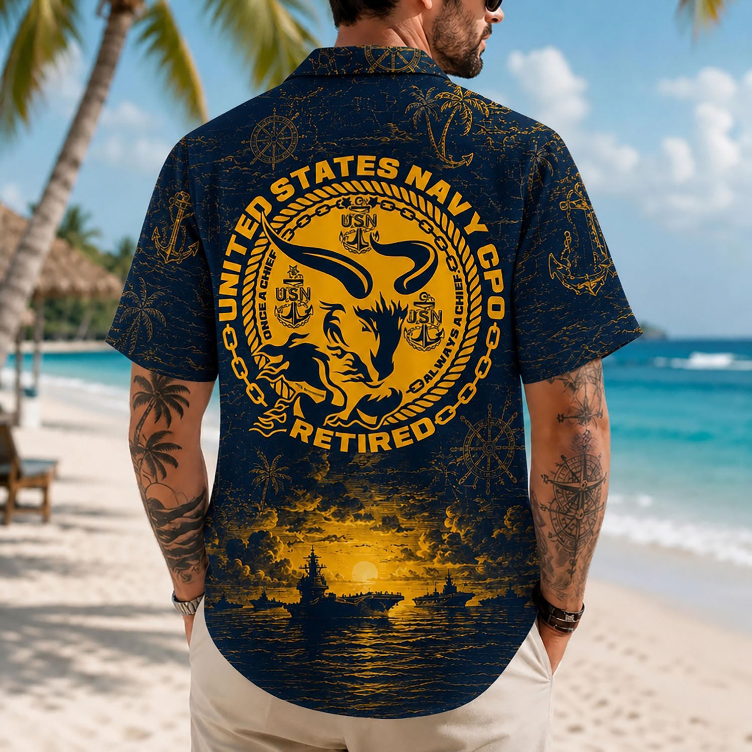 Back view lifestyle of a man on a beach wearing the retired US Navy CPO shirt showcasing the detailed golden goat emblem and warship sunset horizon
