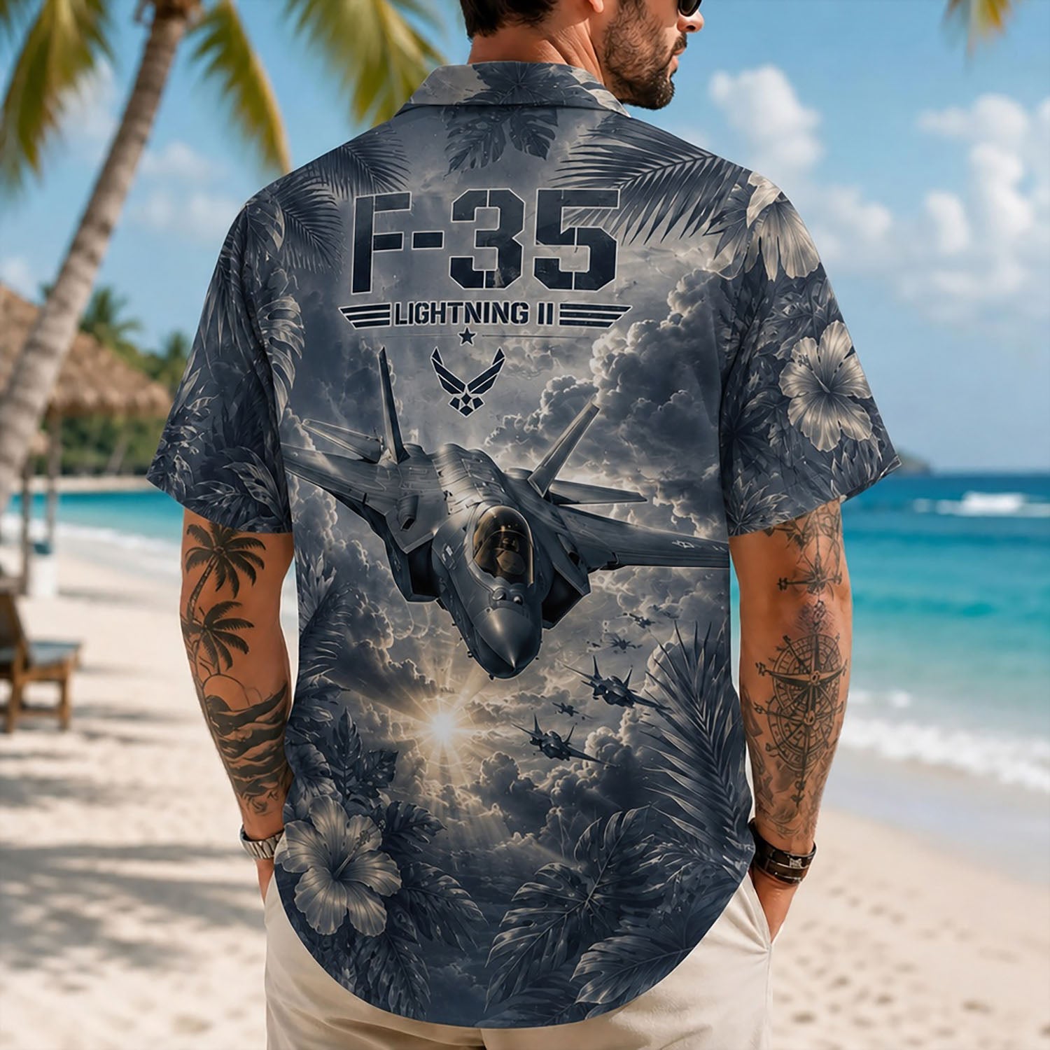 Back view lifestyle of a man showing the striking F-35 formation print, deep-tone tropical monstera leaves, and dynamic sunburst cloud layout