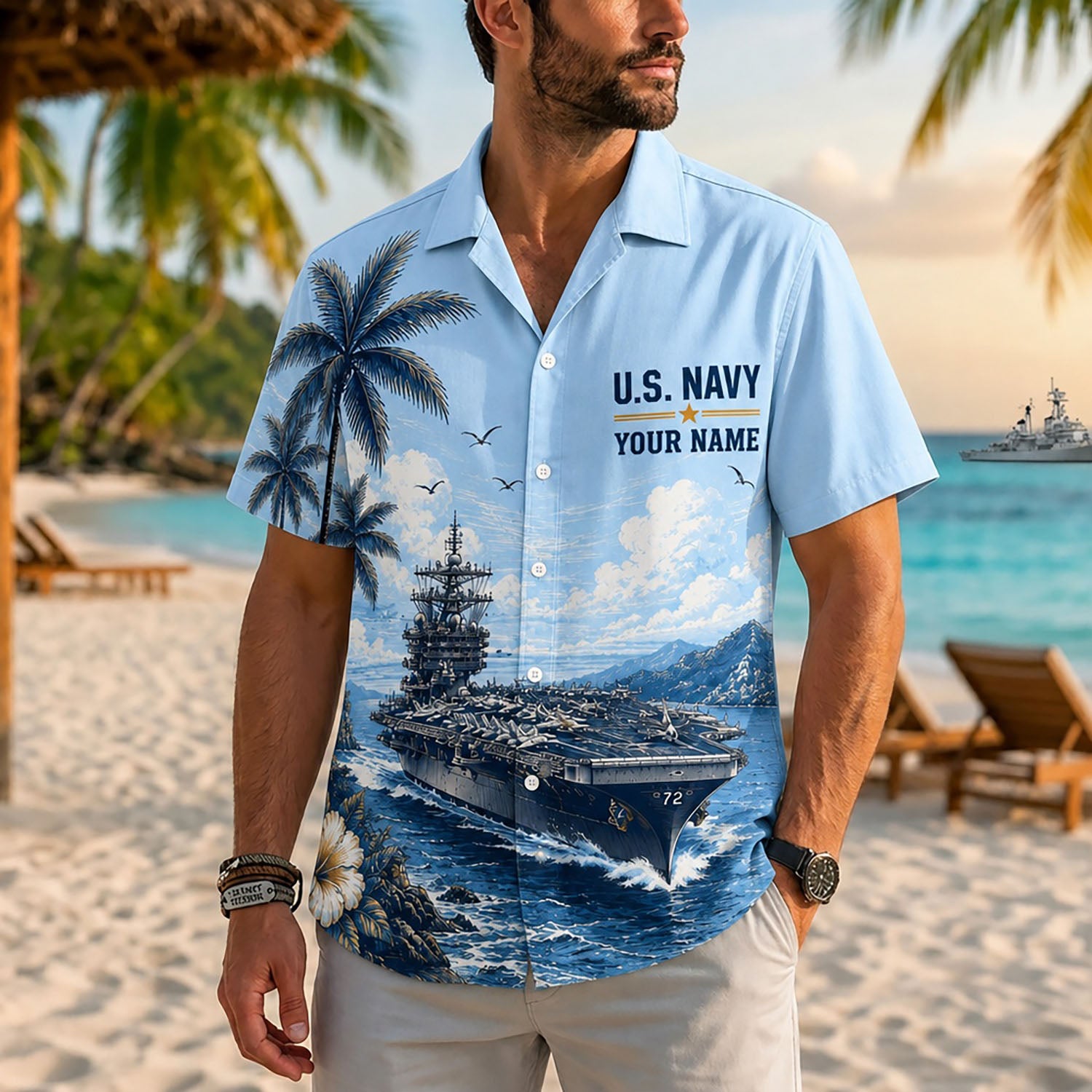 Close-up front view of a male model standing on a tropical beach wearing the personalized light blue USS Abraham Lincoln military Hawaiian shirt