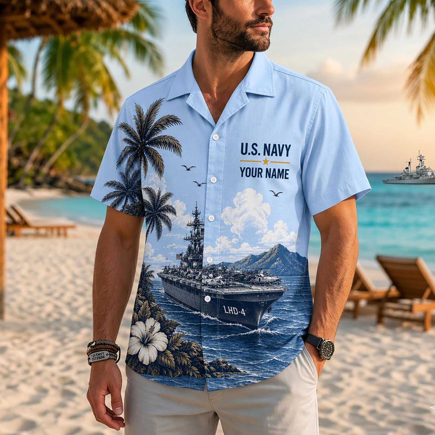 A male model on a tropical beach facing forward wearing the custom light blue USS Boxer LHD-4 US Navy Hawaiian shirt