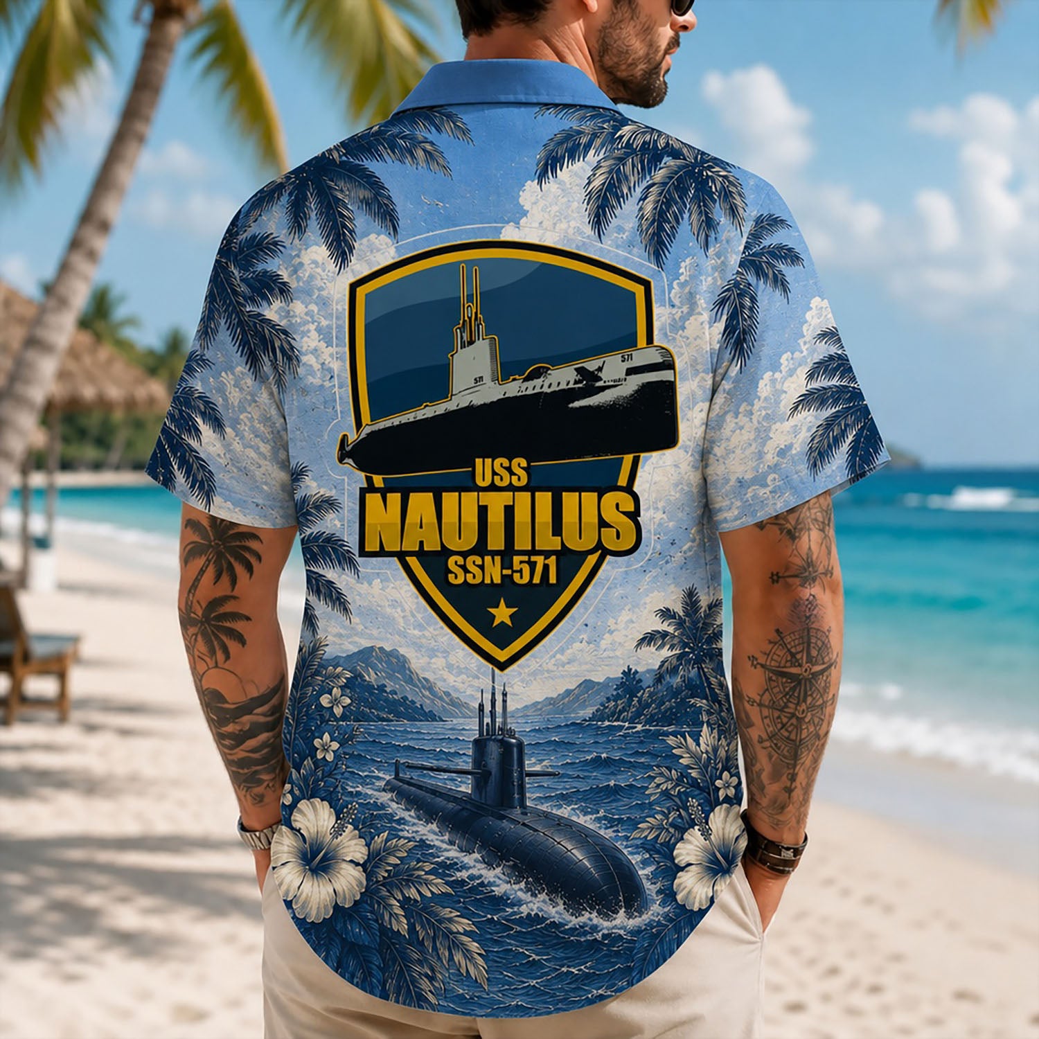 Back view lifestyle of a man on a beach wearing the custom navy veteran shirt showing the large USS Nautilus SSN-571 shield print