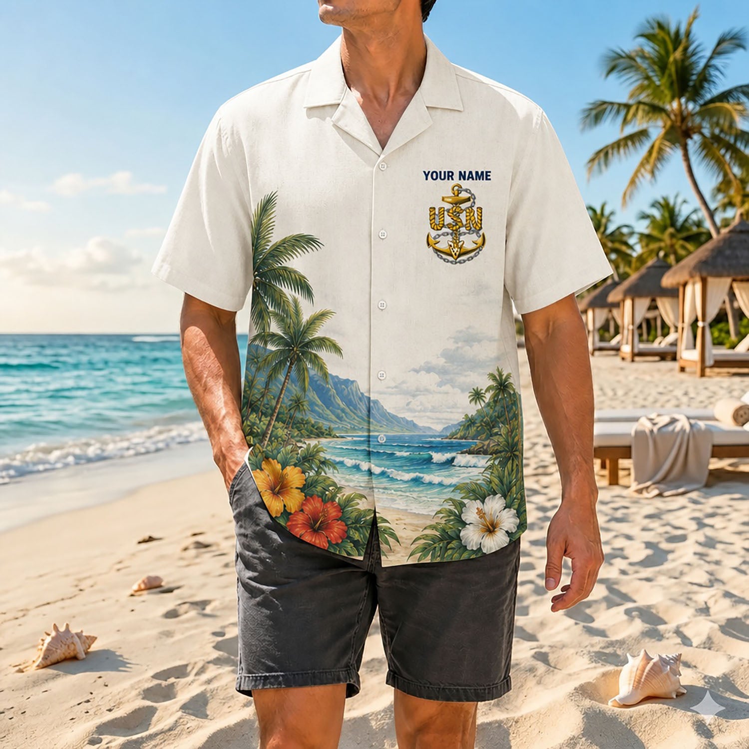 Full shot of a male model posing on the sand wearing the custom Navy Chief veteran shirt paired with dark grey casual summer shorts