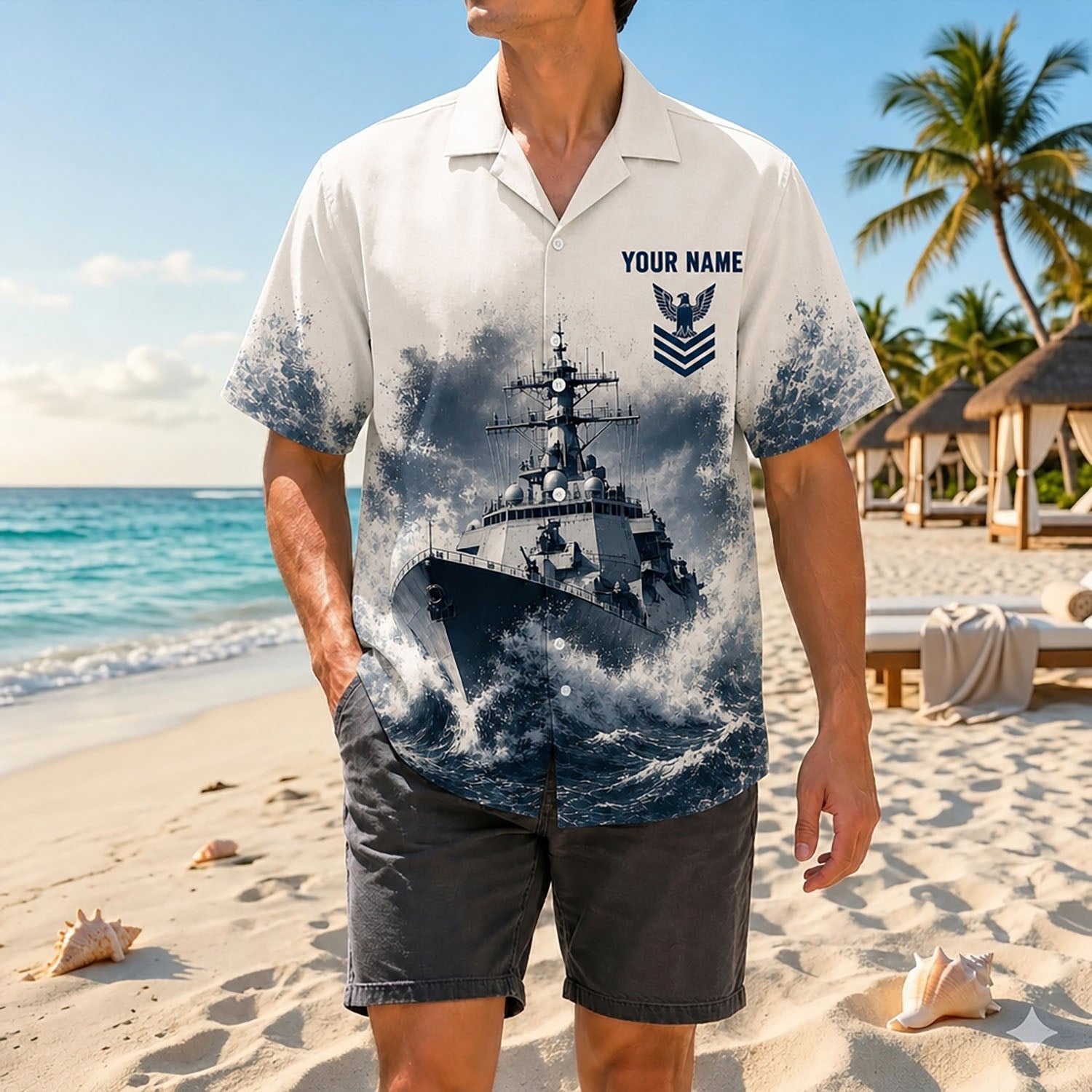 Full shot of a male model posing near the sea wearing the custom Navy warship veteran shirt with dark casual beach shorts